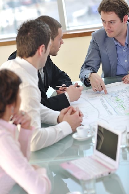 A group of business professionals collaborating around a table, reviewing export compliance documents and discussing strategies for adapting to the new regulations.