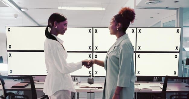 A diverse team of data scientists collaborating in front of a large monitor displaying complex data visualizations. The image represents the talent and expertise required for successful AI implementation.
