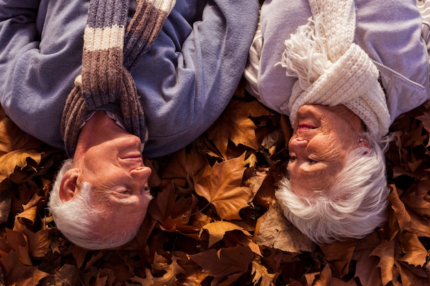 An eye-level shot of a senior couple sitting at a wooden table in their cozy living room, reviewing estate planning documents together. The room is warmly lit, with bookshelves and family photos visible in the background, suggesting a secure and comfortable home environment.