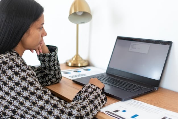 A person sitting at a desk, looking thoughtfully at a laptop displaying a financial planning spreadsheet.